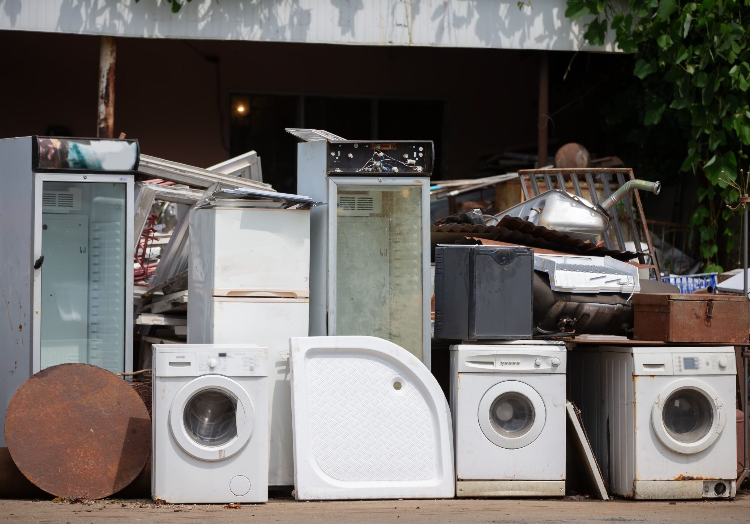 Old appliances and scrap metal piled outdoors.